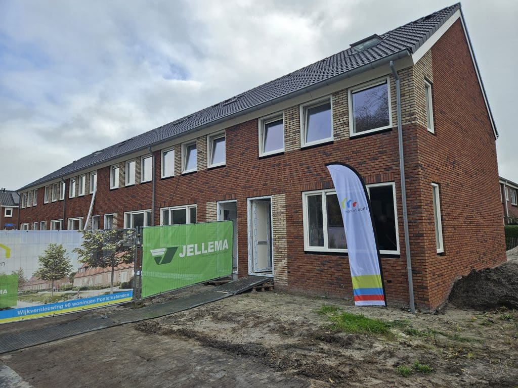 Vandaag vierde Thús Wonen een bijzondere mijlpaal: de feestelijke onthulling van de allereerste thuisbatterij in een sociale huurwoning. De primeur vond plaats aan de Liudgerleane in de woonwijk Fonteinslanden in Dokkum. In deze wijk realiseert Thus Wonen een nieuwbouwproject waar 90 woningen worden gebouwd in twee fasen. In de eerste fase bouwt de corporatie 34 woningen aan de Liudgerleane, de Titus Brandsmastrjitte en de Festus Hommiusstraat. De 34 nieuwe woningen van fase 1 krijgen als onderdeel van de duurzame energievoorziening een innovatieve thuisbatterij. De nieuwbouwwoningen zijn volledig gasloos en uitgerust met een warmtepomp, zonnepanelen én een thuisbatterij met een vermogen van 5 kWh. De thuisbatterij slaat de opgewekte zonnestroom op, waardoor de bewoners ook op momenten zonder zon gebruik kunnen maken van hun eigen energie. Thús Wonen investeert in thuisbatterij voor lagere energiekosten Volgens Rienk van der Meulen, directeur-bestuurder van Thús Wonen is de komst van de thuisbatterij een geweldige stap voorwaarts. “We zijn er trots op dat we als relatief kleine corporatie durven te investeren in dit soort vernieuwende oplossingen. We doen dit omdat het onze huurders direct helpt om prettig te wonen én het energieverbruik laag te houden. Dankzij de thuisbatterij kunnen zij hun eigen zonnestroom optimaal gebruiken en ook in de toekomst rekenen op lagere energiekosten.” Blije bewoners De vaste partner van Thús Wonen voor zonnestroom en opslag is Wocozon. "Samen met woningcorporaties zoeken we naar slimme duurzame energie-oplossingen met als doel veel blije bewoners. Dankzij de combinatie van zonnepanelen met een thuisbatterij hebben ook bewoners in de sociale sector goedkopere stroom en kunnen ze blijven meedoen aan de energietransitie.” zegt Raymond van Hooft, Algemeen Directeur van Wocozon, enthousiast. Toekomstbestendig wonen in Fonteinslanden De nieuwe woningen in de wijk Fonteinslanden worden de komende maanden opgeleverd. In december 2025 zijn de eerste woningen klaar voor verhuur. De laatste woningen van de eerste fase worden in februari 2026 verhuurd. Later dit jaar organiseren Thús Wonen en Wocozon een informatiebijeenkomst, waarin bewoners uitleg krijgen over het gebruik van de thuisbatterij en het kiezen van een passend energiecontract. Met de inzet van thuisbatterijen wil Thús Wonen ervaring opdoen met slim energiebeheer, als onderdeel van haar strategie om woningen toekomstbestendig en duurzaam te maken, zodat huurders fijn en betaalbaar kunnen blijven wonen.